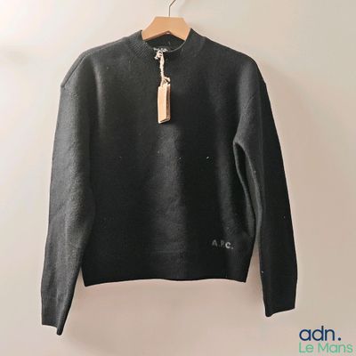 the sweater is hanging on a hanger on the wall