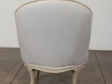 an old chair with a white upholstered back and a beige upholstered seat