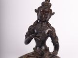 an image of a statue of a woman sitting on a rock