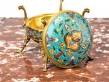 a gold and blue bowl sitting on a marble table