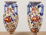 two vases sitting on top of a wooden table next to each other