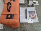 an orange suitcase sitting on the floor next to other items