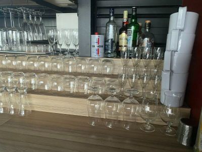 many empty wine glasses on the counter in the bar