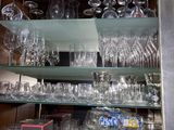a glass shelf with many glasses on it