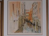 two framed paintings of buildings and a boat in a canal