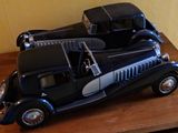 une maquette de voiture noire et argentée posée sur une table en bois