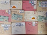 many envelopes with stamps on them sitting on a table