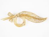 un gros plan d'une broche ornée d'une feuille