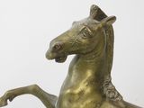 bronze statue of a horse on its hind legs on a white background