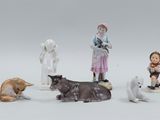 five figurines of people and animals on a white surface