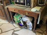 une petite table sur laquelle est posé un micro-ondes