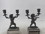 a pair of bronze figurines of a boy and girl holding candles