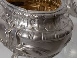 two silver pots sitting on a glass table