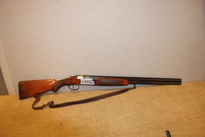 Le fusil est posé sur la table près du mur.