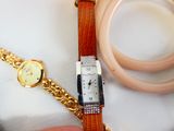 une montre et un bracelet posés sur une table, à côté d'un bracelet