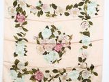 un foulard à motifs floraux blancs et roses accroché au mur