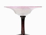 pink and white glass bowl on a wooden stand on a white surface