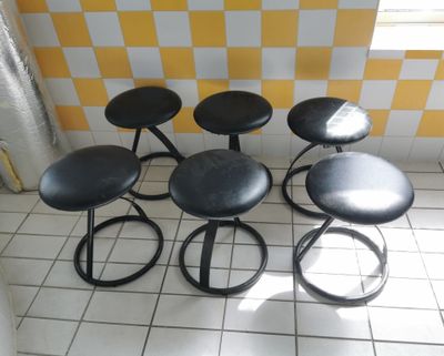 four stools sitting on a tiled floor in a room