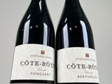 two bottles of wine sitting on top of a table next to each other
