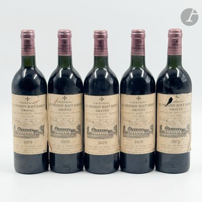 six bouteilles de vin sont alignées sur une surface blanche