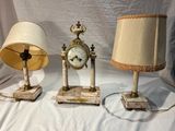 trois lampes et une horloge posées sur une table