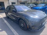 2020 ford mustang macht in a parking lot with other cars in the background