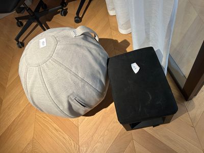 a laptop and a ball on the floor next to a chair