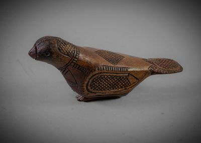 an old wooden bird with a decorative pattern on it ' s body