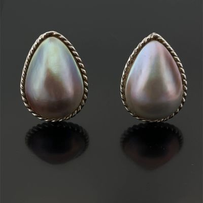 an image of a pair of pearl earrings on a black surface