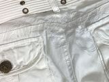 the pants are white and have buttons on them and a black and white striped shirt