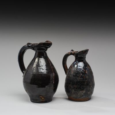 une paire de vases noirs posés l'un sur l'autre sur une table