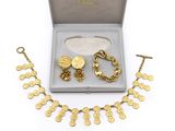 une photo d'un ensemble composé d'un collier et d'un bracelet en or, présenté dans un coffret