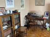 a room with a desk, bookshelf, and a chair in it