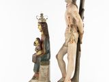 a statue of a man holding a cross next to a statue of a woman