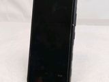 the back of a black cell phone sitting on top of a white surface