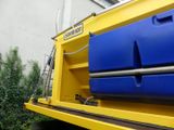 a yellow and blue truck with a blue bin on the back
