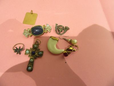 a lot of jewelry that is laying on a pink surface