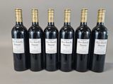 six bottles of wine are lined up in a row on a table
