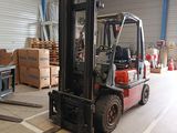 a forklift in a warehouse with boxes in the background