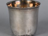 a close up of a silver cup sitting on a table