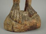 a wooden sculpture of a person holding a bird