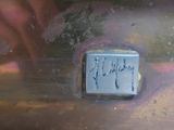 a close up of a person ' s hand writing on a piece of metal