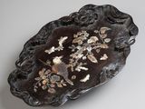 an image of a black and gold plate with flowers on it