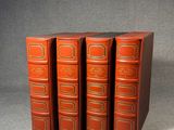 trois livres rouges empilés les uns sur les autres sur une surface grise