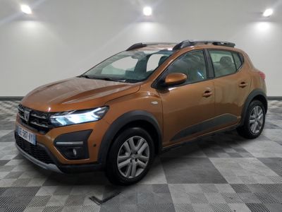 Une voiture marron est garée dans une pièce au sol à carreaux.