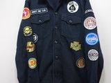 une veste en jean ornée de patchs, suspendue à un cintre