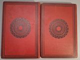two red books sitting on top of a table next to each other