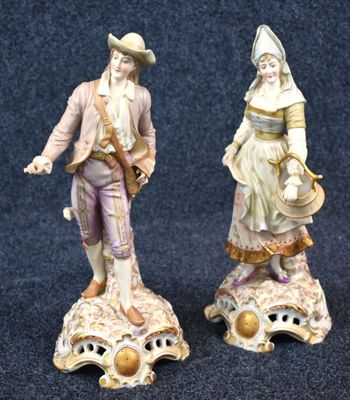 deux figurines représentant un homme et une femme debout sur un coquillage