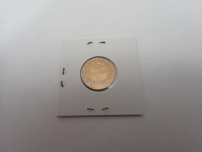 un gros plan sur un morceau de papier dans lequel se trouve une pièce de monnaie