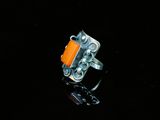 Gros plan sur une bague contenant une pierre orange